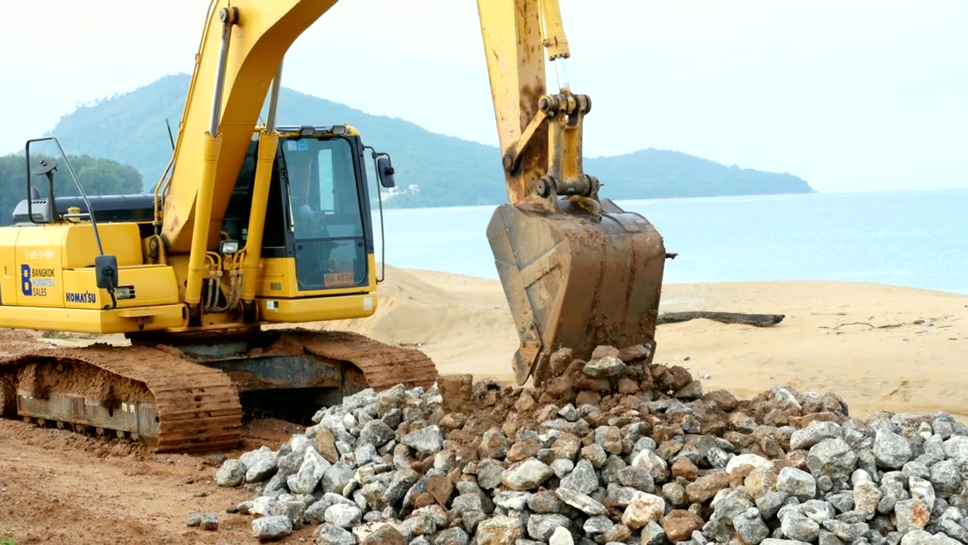 Compact loader moving rock